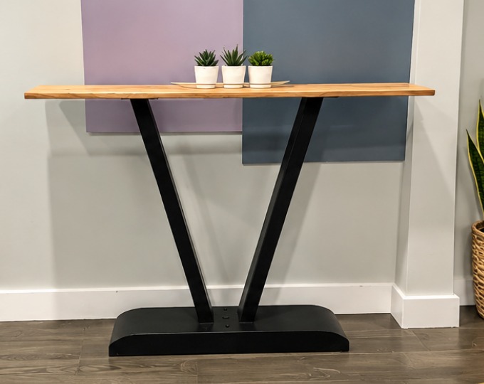 Custom console table with a natural wood top and a black V-shaped metal base, built by Handyman Reid in Edmonton