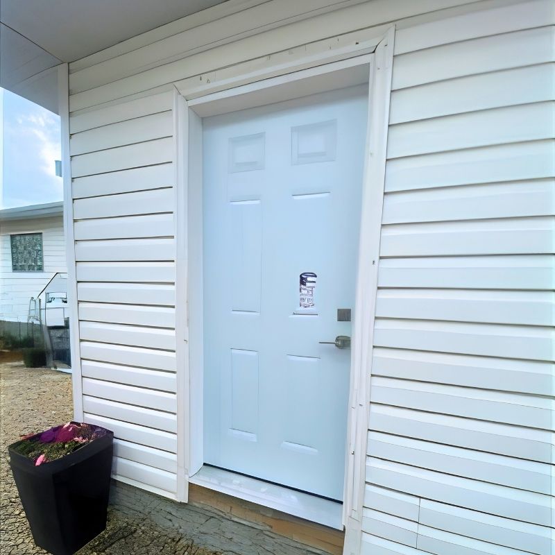 New white exterior entry door installed in vinyl siding in Edmonton