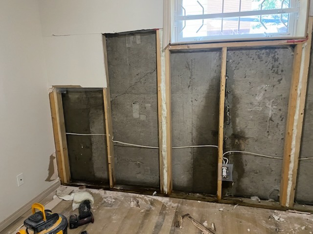 Wall opened up to the studs showing dark staining inside the wall cavity during mold remediation